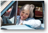 Woman smiling at wheel of car